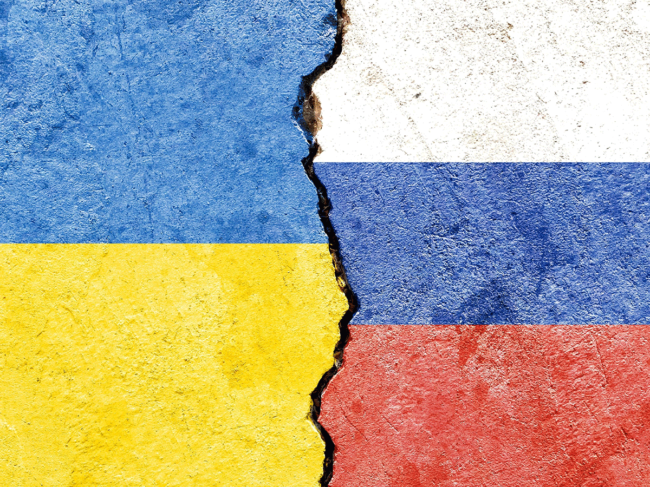 Ukrainian and Russian flags painted on cracked concrete
