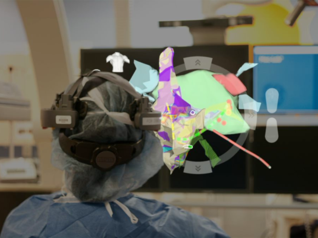 Surgeon wearing headset looks at AR model