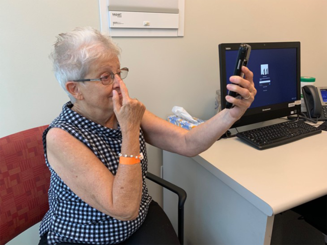 Kathryn Atkinson, an elderly patient, participating in a smartphone screening test to analyze stroke-like symptoms