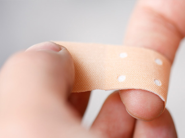 Putting band-aid on finger