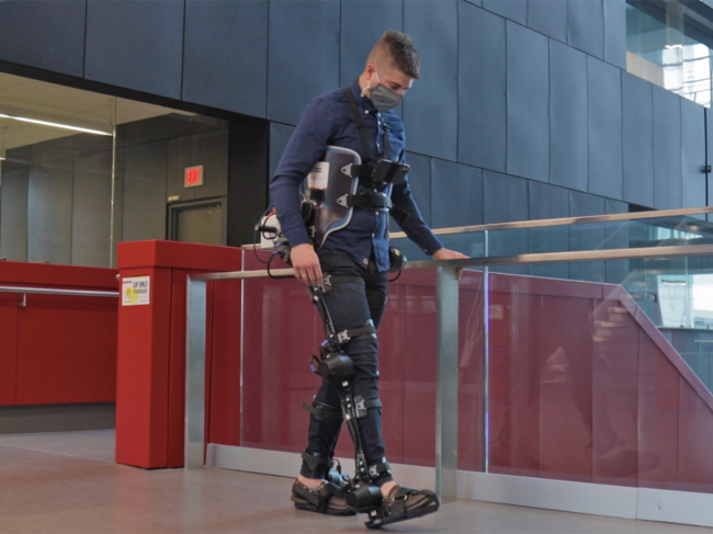 Brokoslaw Laschowski wearing exoskeleton in front of a stairway