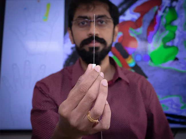 Santosh Chandrasekaran holding SEEG electrode 