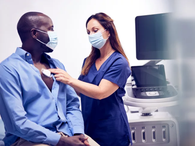 A care provider applies Philips MCOT patch on patient