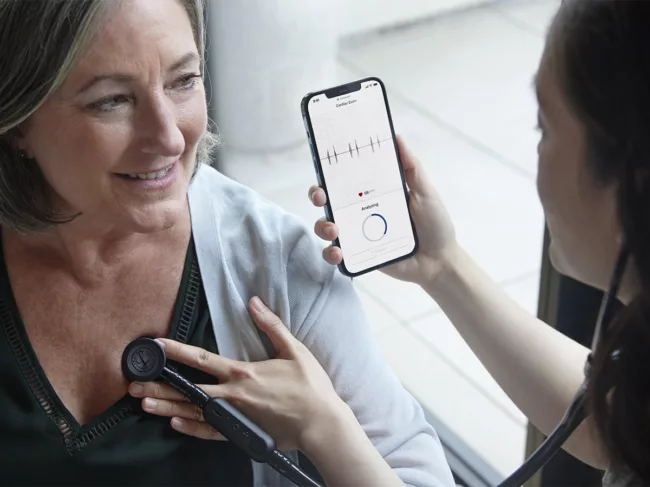 Doctor uses Eko app while listening to patient's heart