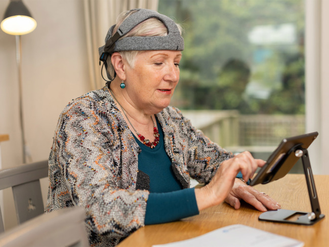 Lady wearing Cumulus EEG headset using tablet