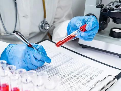 Scientist with blood test tubes
