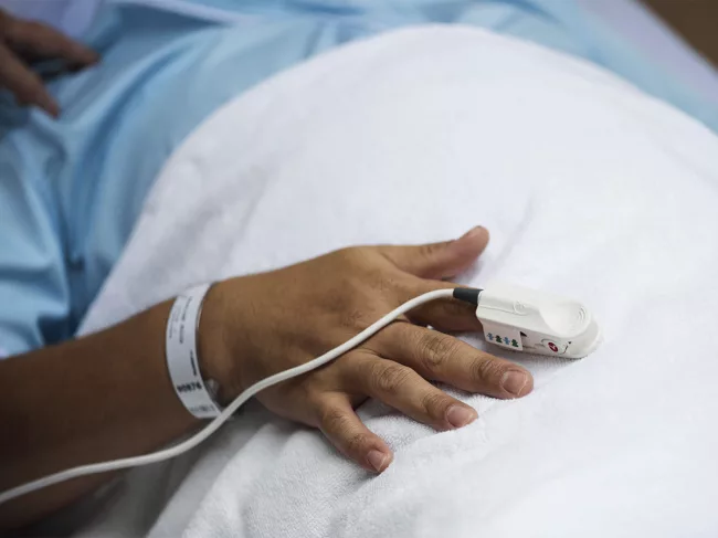 Hospital patient wearing pulse oximeter