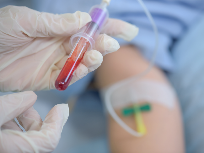 Phlebotomist draws blood from patient