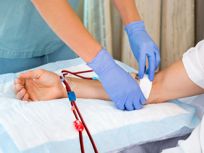 Nurse starting dialysis on a patient