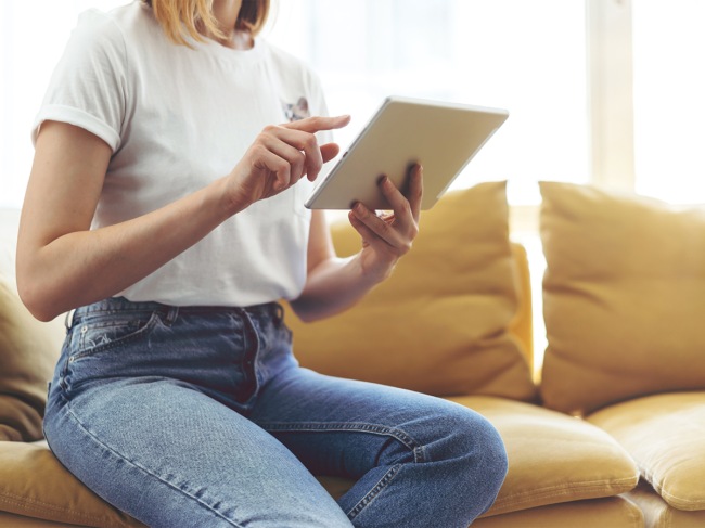 Woman on couch using tablet
