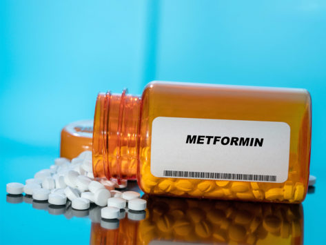 White tablets spilling out of a bottle labled Metformin