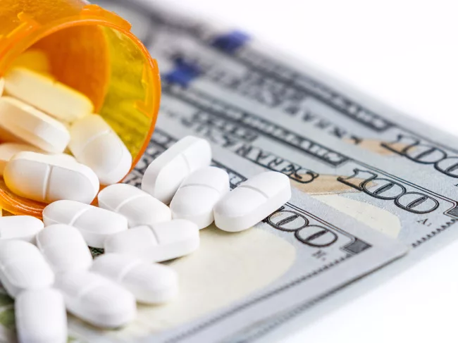 Pills, bottle on $100 bills