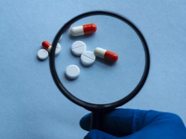 Pills under magnifying glass