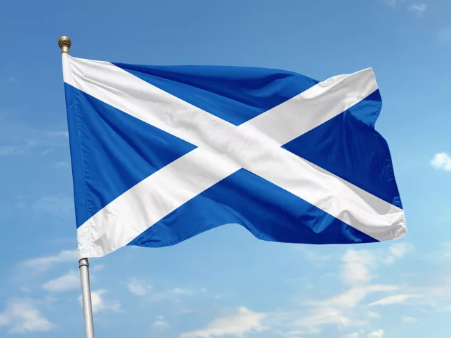 Flag of Scotland against blue sky