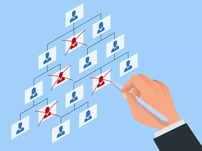 Hand crossing out employees on organizational chart