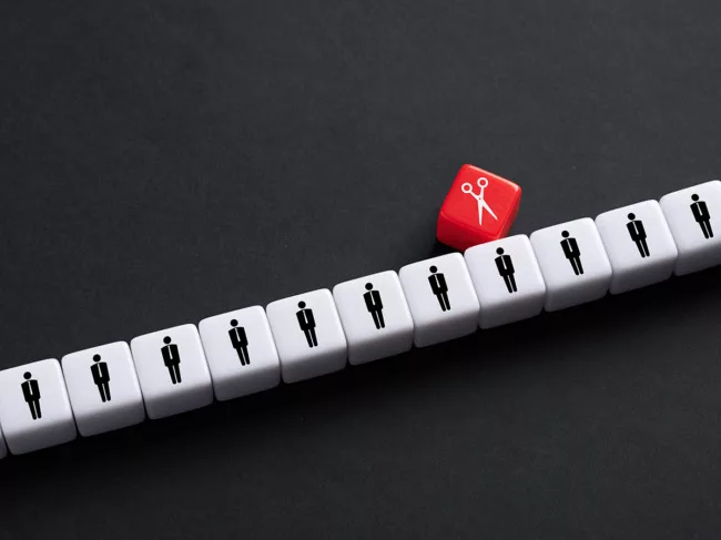 Row of white dice with people icons, red die with scissors