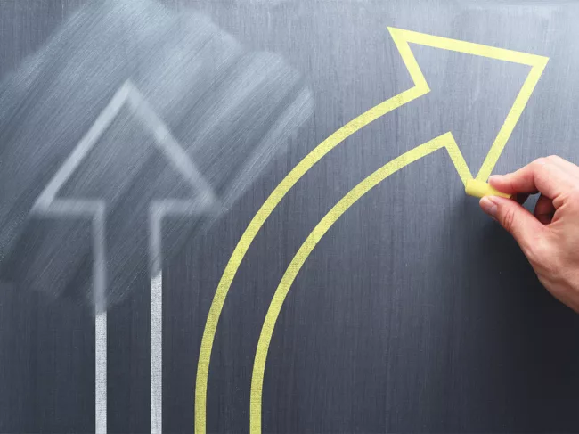 Chalkboard with straight arrow erased, drawing a turning arrow