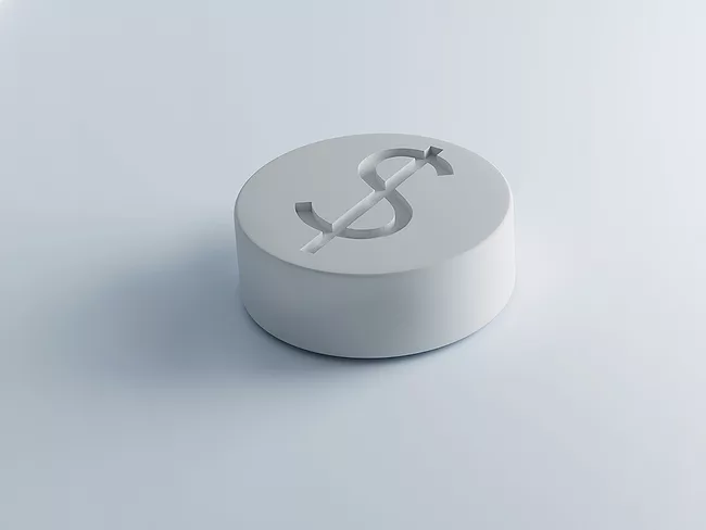 White tablet imprinted with dollar sign
