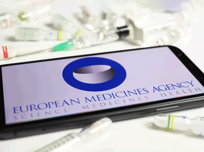 EMA logo on mobile screen, vials, syringes