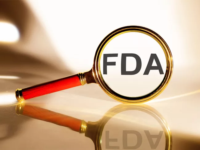 Photo of magnifying glass inspecting the text FDA
