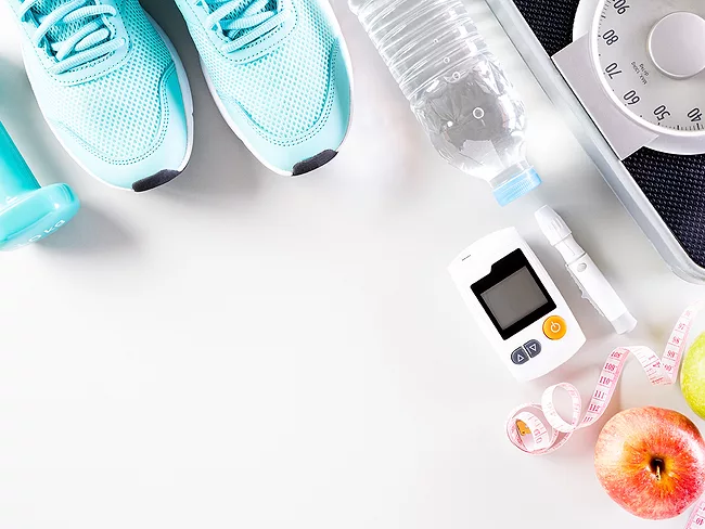 Hand weight, sneakers, scale, measuring tape, apple, injector and glucose monitor
