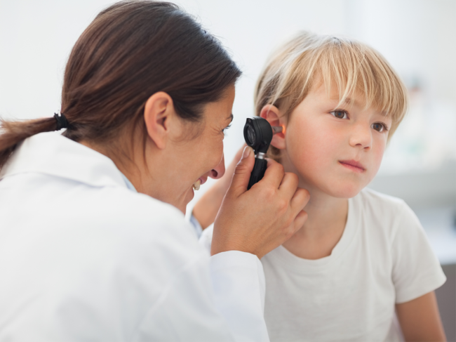 Doctor looking in child's ear