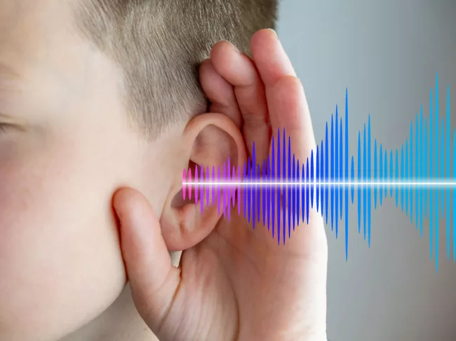 Boy cupping ear with soundwave graphic