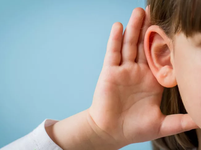 Child cupping hand to ear