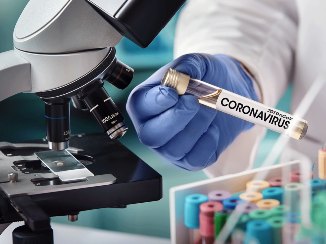 Coronavirus test tube, microscope, gloved hand