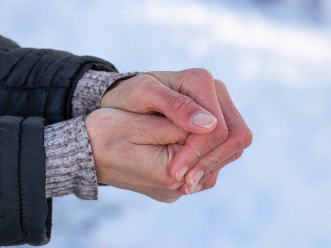 Cold hands against snowy background