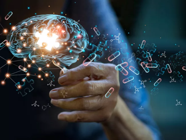 Elderly woman holding illustration of brain with missing puzzle piece