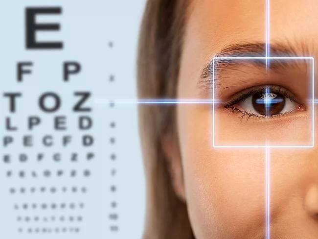 Eye chart and teen with laser over eye